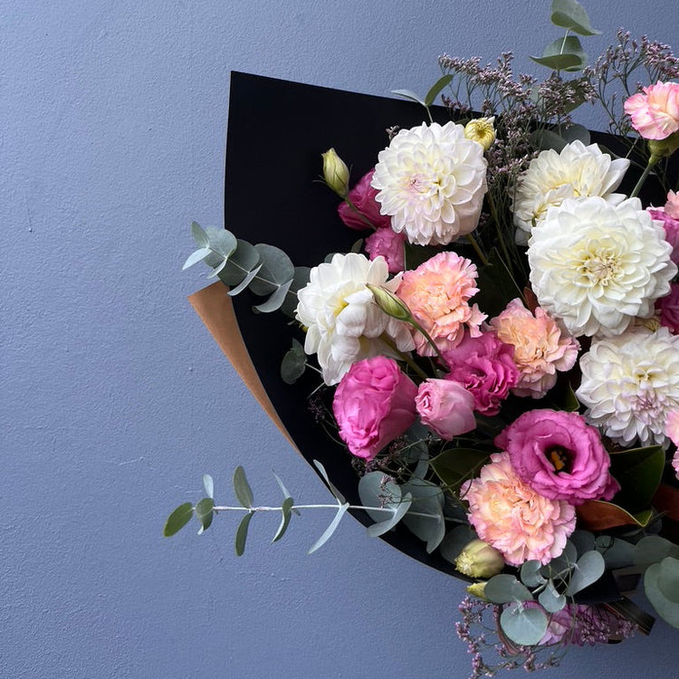 Bouquet of flowers with pink and white flowers against a blue background