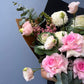 Bouquet of pink and white roses with greenery against a blue background
