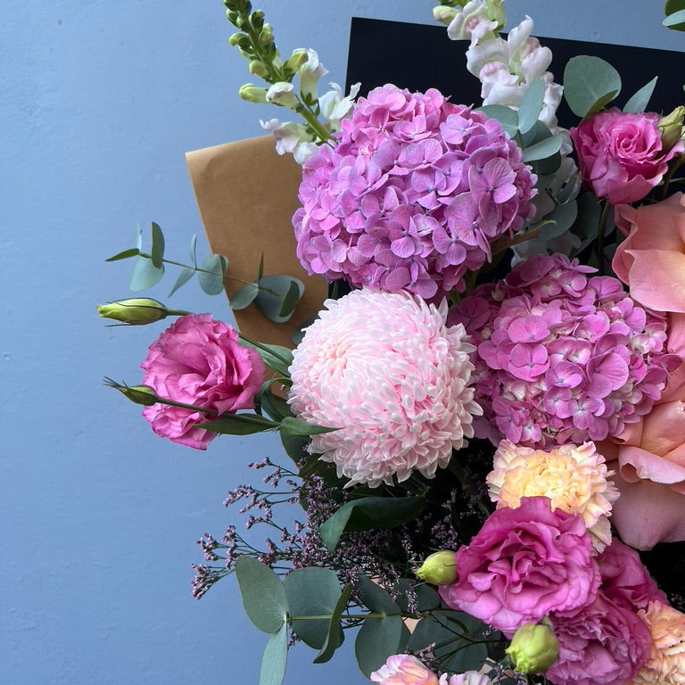 Bouquet of pink and white flowers with a blue background